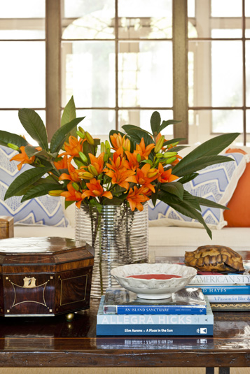 Kaufman Residence, decorated by Phoebe Howard, coffee table detail in living room-----
Interior of living room showing close-up of lilies in vase beside books on coffee table.